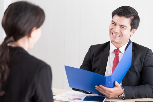 A businessman listens and talking to candidate woman answers for a job interview.