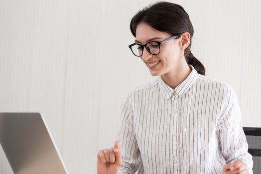 A businesswoman wearing glasses working with smiling and happiness at the office.