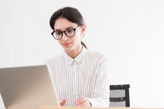 A businesswoman wearing glasses working with smiling and happiness at the office.