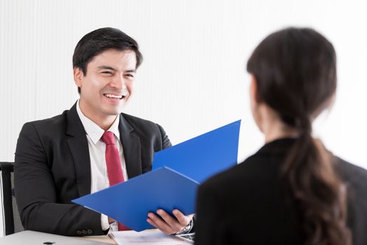 A businessman listens and talking to candidate woman answers for a job interview.