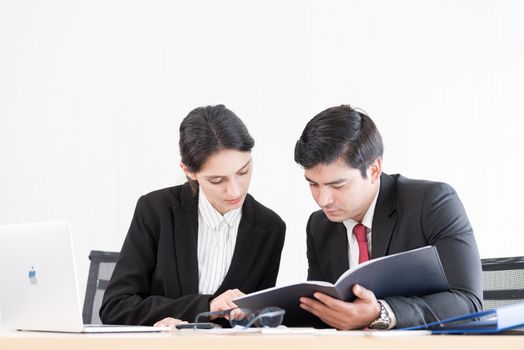 A manager and secretary working together in the office.