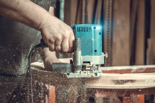 wood milling with electric cutter in joinery. color toning