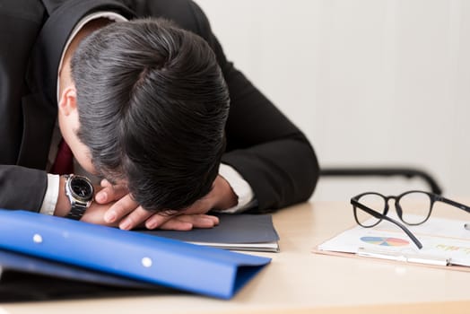 A businessman slept in the working time at the office.