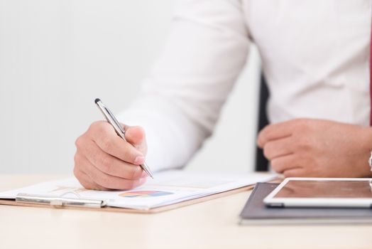 A businessman has writing the document report.