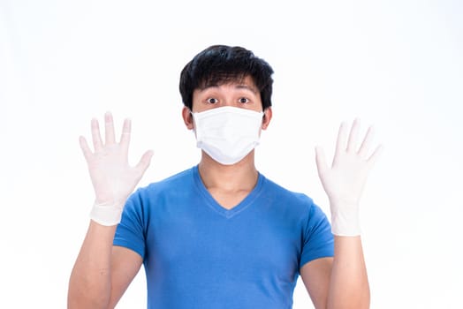 Asian young man in blue t-shirt top with medical mask and latex gloves to protect COVID-19 with isolated on white background concept.