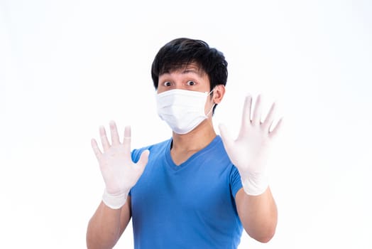 Asian young man in blue t-shirt top with medical mask and latex gloves to protect COVID-19 with isolated on white background concept.