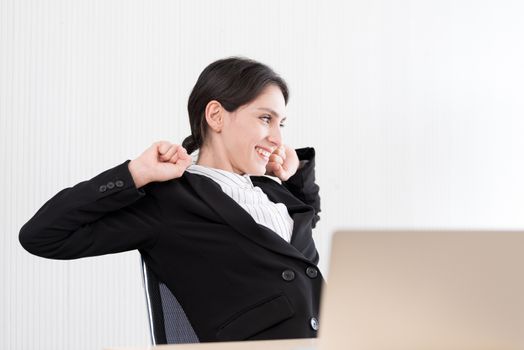 A businesswoman has taken a rest and stretching on the office chair with smiling and happiness.