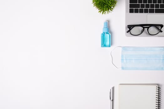 The equipment to protect COVID-19, blue mask and hand cleaner gel for preparing to work from home Isolated on white background concept.