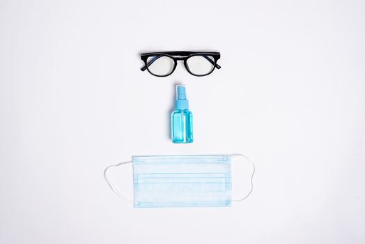 The face of equipment to protect COVID-19, eyeglasses, blue mask, and hand cleaner gel Isolated on white background concept.