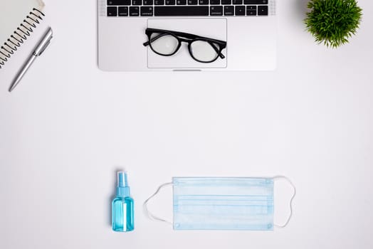 The equipment to protect COVID-19, blue mask and hand cleaner gel for preparing to work from home Isolated on white background concept.