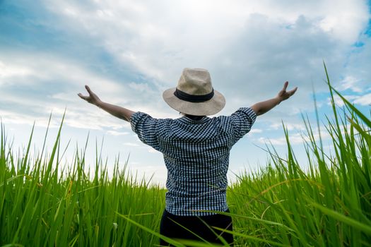 The back of a rural woman raising her hand to the sky