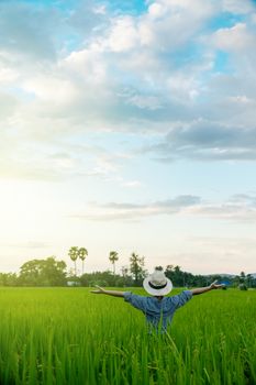 Behind the farmer woman's hands raised in the sky in a field with sky background