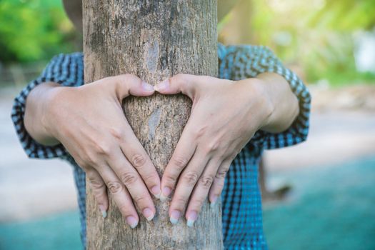 A rural woman made a heart-shaped hand to show love for the tree.