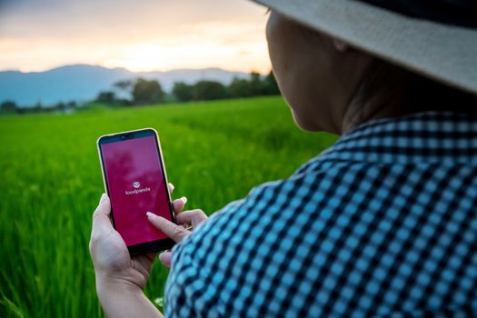 Chiang mai, Thailand - October 16, 2019: Rural women are using the Foodpanda application when she is in the fields