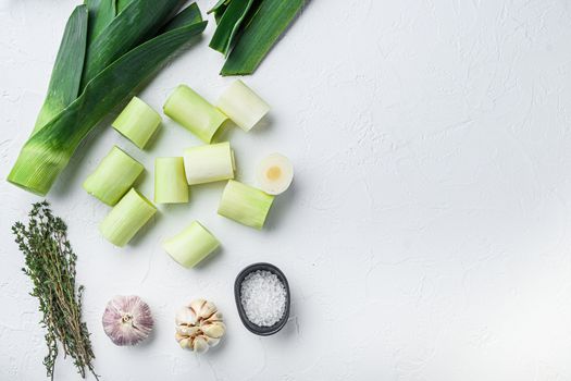 Raw chopped Leeks for grill uncooked with herbs ingredients , on textured white background top view with space for text