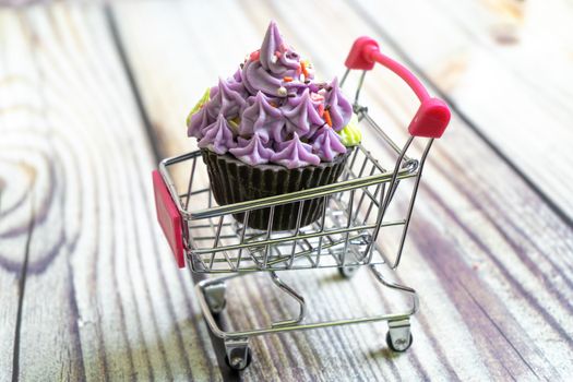 beautiful cupcake dessert sweet soap placed in a shopping cart on a wooden background. Shows hobbies and skills that people are learning in the pandemic. Shot with copyspace for text