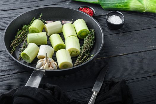 Raw braised Leek sultan on grill pan uncooked with herbs ingredients , on black wooden table side view with space for text
