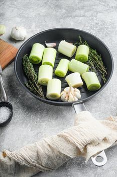 Raw braised Leek sultan on grill pan uncooked with herbs ingredients , on grey textured background side view