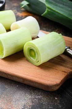 Raw chopped leek for cooking Braised Leeks with herbs ingredients , on rustic metall background dark, side view