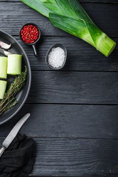 Raw leeks sultan chopped oninon on grill pan uncooked with herbs ingredients , on black wooden table top view with space for text