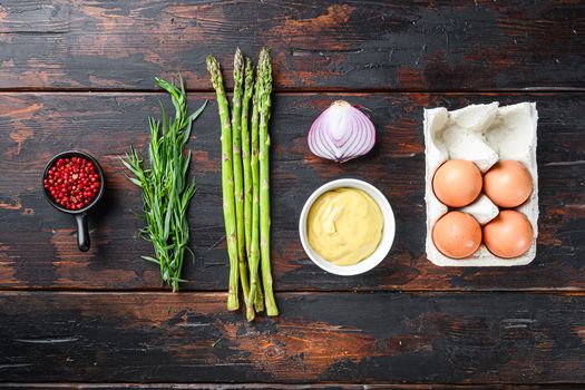 Fresh asparagus eggs and french dressing ingredients with dijon mustard, onion taragon on dark wooden old background, top view