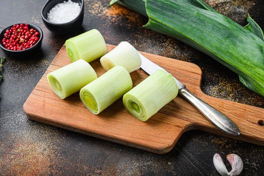Chopped leek for cooking Braised Leeks with herbs ingredients , on rustic metall background dark, side view