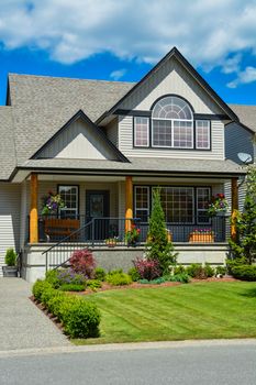 Suburban house with landscaping in front and blue sky background