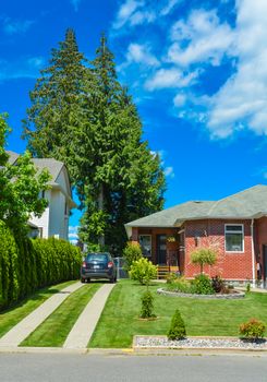 Family house with traced driveway and parked car on it. Fragment of a house on blue sky background