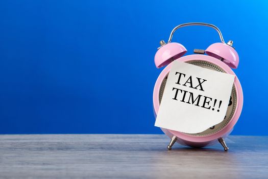 Tax Concept - A Clock with sticker note written TAX TIME