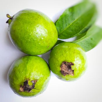 Green color guava with leaves arranged beautifully with color papers on background and good for health and skin and Help Lower Blood Sugar Levels