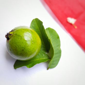 Green color guava with leaves arranged beautifully with color papers on background and good for health and skin and Help Lower Blood Sugar Levels