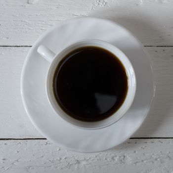 Coffee cup and saucer on a white wooden table