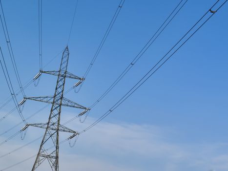 Electricity power supply pylon with a blue sky and clouds background