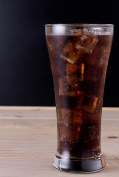 Glass of cola with ice cube, copy space