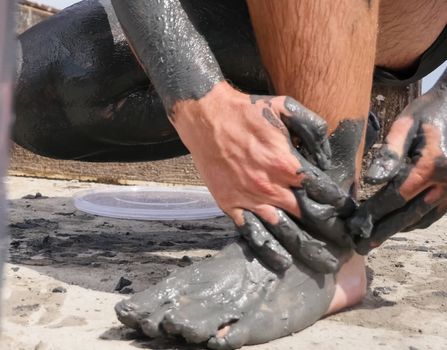 People are wiped with mud. Mud baths in Spain.