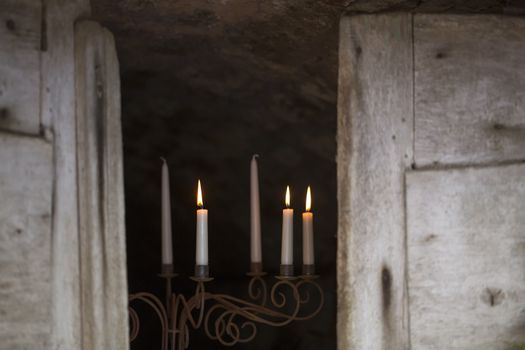 Candle sticks with candlelight in the entrance to a vaulted cellar