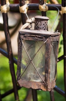 Antique rusty metal lantern hanging on a fence