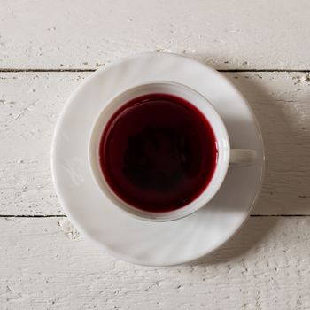 Cup of Karkadeh Red Tea on wooden table