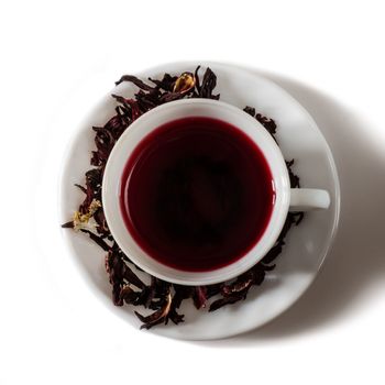 Cup of Karkadeh Red Tea with Dry Flowers isolated on a white background