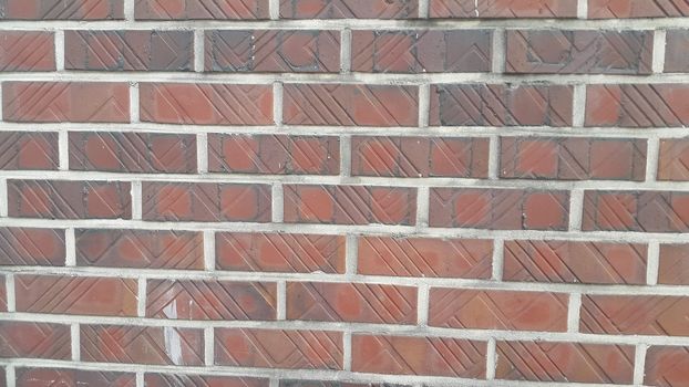 Closeup texture of red brick wall. A background of a weathered old exterior brick wall in the sunshine.