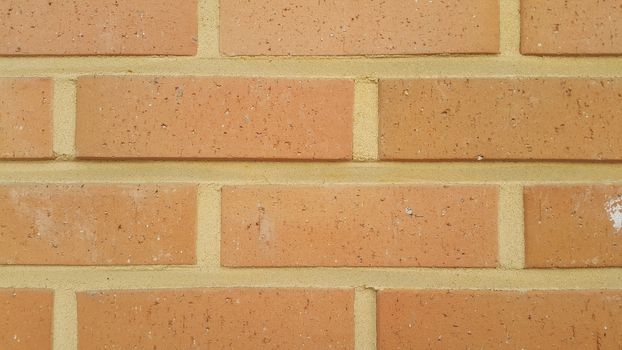 Closeup texture of red brick wall. A background of a weathered old exterior brick wall in the sunshine.