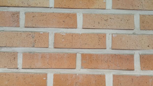 Closeup texture of red brick wall. A background of a weathered old exterior brick wall in the sunshine.