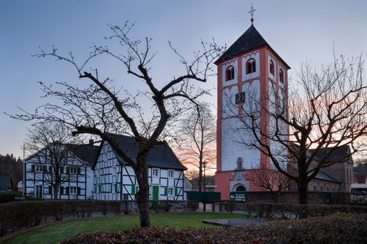Center of village Odenthal with parish church and old buildings at sunrise, Bergisches Land, Germany