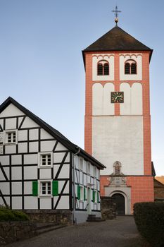 Center of village Odenthal with parish church and old buildings at sunrise, Bergisches Land, Germany