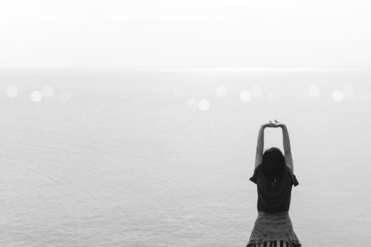 Woman rise hands up to sky freedom concept with blue sky and summer field background.