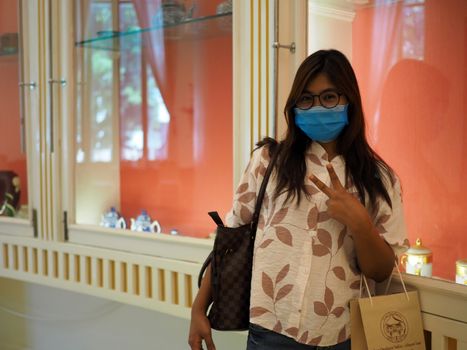 Woman with face protective mask looking at the camera in mall. new normal concept. COVID-19 and mask protective concept.