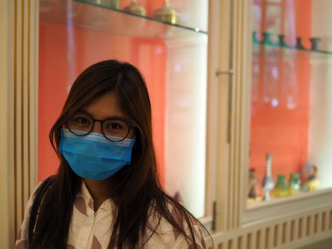 Woman with face protective mask looking at the camera in mall. new normal concept. COVID-19 and mask protective concept.