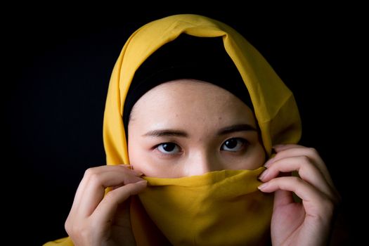 beautiful mysterious young woman wearing scarf close up.