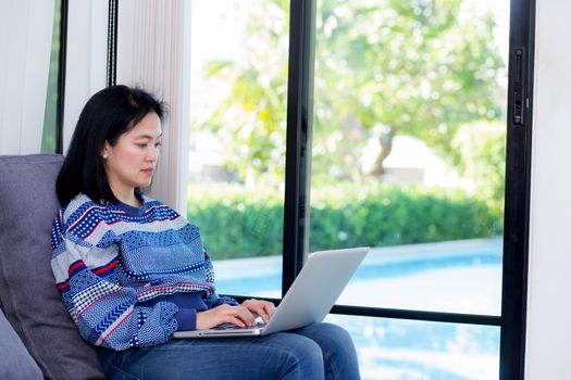 Closeup computer notebook on sofa with asian woman for work in lifestyle of woman concept