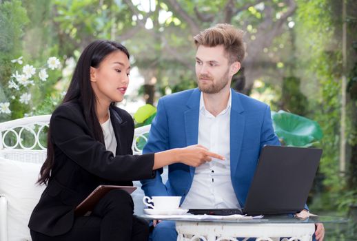 technology and office concept - two business man and woman with laptop - tablet pc computer and papers having discussion in office.